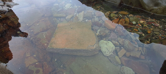Clear water revealing colorful riverbed stones