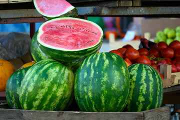 Ripe Watermelons with Sliced Fruit at Market