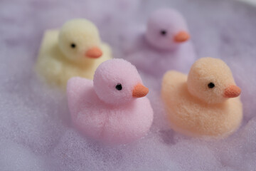 Pastel plush ducks float in soft, dreamy bubbles