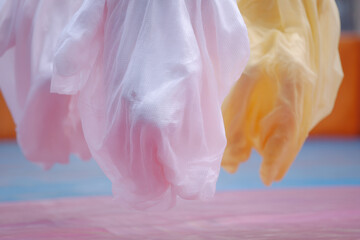 Pastel fabric floats gently in air, creating dreamy atmosphere