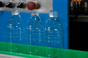 The  empty drinking water bottles on the conveyor belt for filling process.