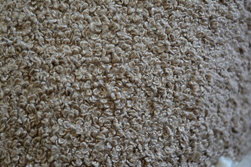 Close-up texture of beige looped carpet or upholstery fabric. Abstract neutral background with soft...
