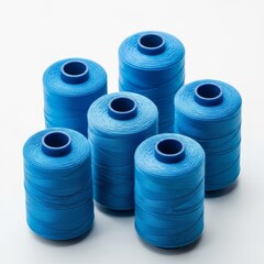 Spools of blue thread on a solid white background, sewing and crafting resource image
