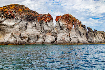 Mexican coastal landscape with volcanic lava rock formations, Coronado Island, grayish slope and brown color on the top, cloudy day in Loreto Bay National Marine Park in Baja California Sur, Mexico