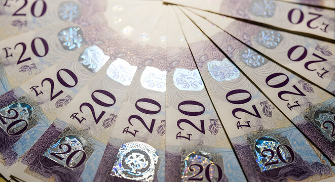 Overhead Close up of Fanned Twenty Pound Sterling Banknotes Displaying Intricate Details and Color Variations on a