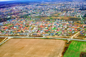 Aerial view of autumn Zymna Voda village colorful detached houses, roads and fields in Lviv region, Ukraine