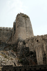 View from below of a tall fortress tower built into the rock, part of Golubac Fortress, Serbia. A...