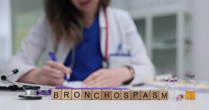 Wooden blocks with Bronchospasm on desk with female doctor writing in patient history. Respiratory health diagnosis and management of bronchospasm
