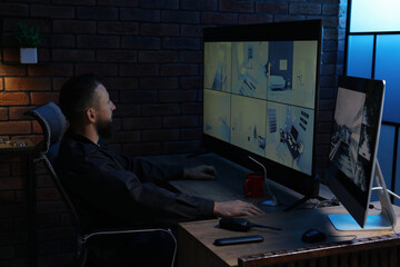 Security guard monitoring CCTV cameras in office at night