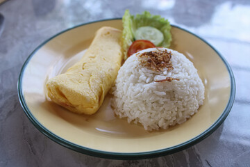 Delicious Indonesian Breakfast with Rice and Omelette on a Plate