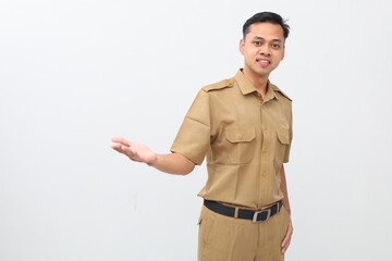 Cheerful Indonesian government staff standing while presenting something beside him