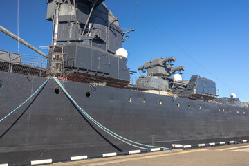 The museum ship is moored at the eternal parking lot in the port of Novorossiysk. A Soviet cruiser in the port. A warship with guns. 