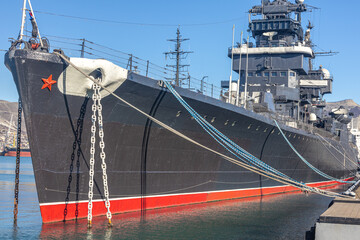 The museum ship is moored at the eternal parking lot in the port of Novorossiysk. A Soviet cruiser in the port. A warship with guns. 
