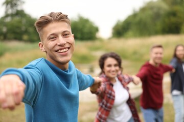 Team building. Group of happy people holding hands outdoors, selective focus