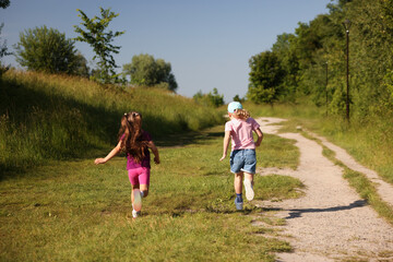 Obraz premium Cute little girls running in nature, back view