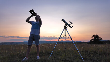 Amateur astronomer using telescope and binoculars for watching stars, Moon, planets and other...