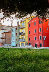 Cityscape of old district of city of Sottomarina in Italy with preserved protective wall protecting from  waves of  sea surrounded by trees creating a serene urban neighborhood environment.