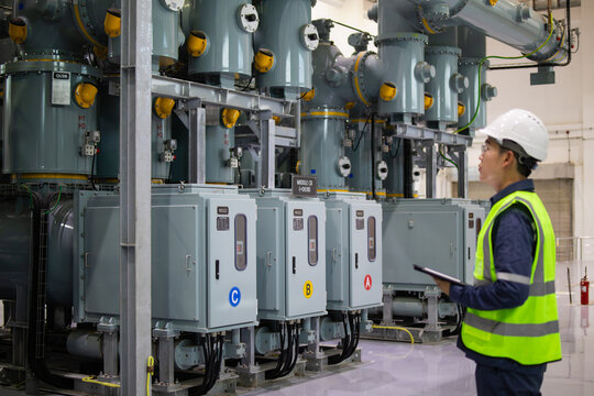 Power station staff inspect electrical equipment in high voltage industrial facility ensuring safety and functionality with careful attention and professional expertise in clean environment