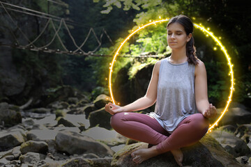 Woman meditating in Lotus pose in mountains. Bright bubble around her representing aura