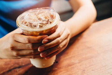 Close-Up View of Hands Holding Iced Coffee Drink