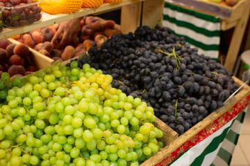 shelves in a vegetable store, brightly colored vegetables and fruits grape