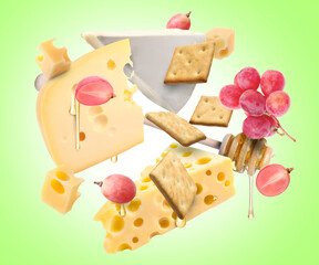 Cheese board products in air on light green background. Different types of cheese, grapes, crackers and honey