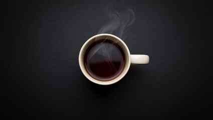 A top view of a steaming cup of coffee on a dark background