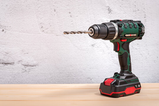 Screwdriver drill on a wooden background