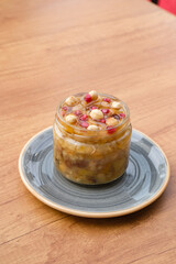 Traditional Turkish ashure with chickpeas, pomegranate, and dried fruits. served cold. multigrain dessert.