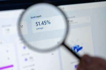 Magnifying glass inspecting key website scroll depth data on a computer screen, showcasing crucial digital marketing analytics to improve user engagement and web optimization efforts