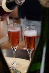 Pouring and tasting of rose or pink cuvee sparkling wine brut, grand reserve, champagne in Ay-Champagne wine making village in Vallee de la Marne, , Champagne region, France