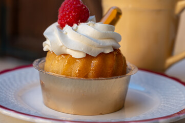 French cuisine, fresh baked baba au rum cake with chantilly cream, sweet dessert with rum close up