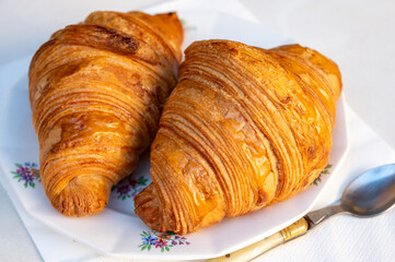 Fresh baked two buttered croissants served in restaurant for continental or French breakfast on board