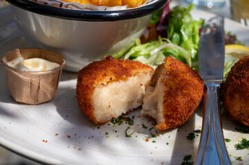Lunch in cafe with vegetarian cheese and green asparagus croquettes served with fresh salad and french fries potato in Bruges, Belgium