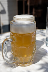 Belgian beer in glasses in old brewery in Bruges, light or dark, tasty beverage, lunch with beer, tourist destination, Flanders, Belgium