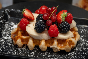 Baked belgian sugar waffles with various toppings, delicious sweet street food in Bruges, Flanders, Belgium