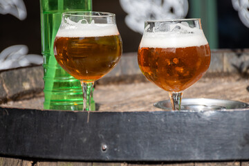 Belgian beer in glasses in old brewery in Bruges, light or dark, tasty beverage, lunch with beer, tourist destination, Flanders, Belgium