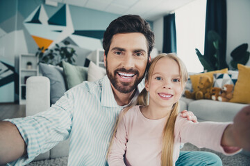 Father and daughter sharing a joyful moment together at home, spending quality time in a...