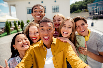 Happy young diverse friends enjoying an outdoor adventure day, capturing a joyful selfie in an...