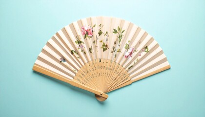 _Elegant decorative fan adorned with vibrant floral design on soft pastel background.