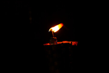 burning candle on black background
