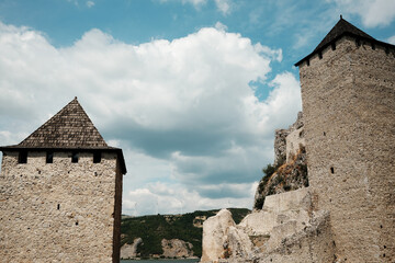 A majestic view of Golubac Fortress with its medieval towers rising against the blue summer sky....