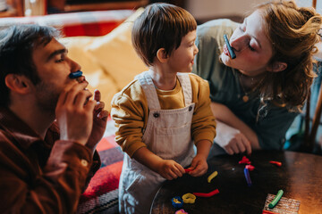A joyful family moment featuring caregivers and a child bonding through play and creativity at home. Emphasis on imaginative activities and the warmth of familial interaction.