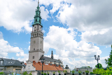 Catholic monument in the city of Częstochowa against the background of a blue sky with white clouds © Olha Faul