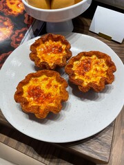 Three egg tarts display food / sample dishes