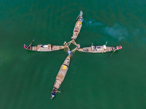 Aerial view of boats clustered together on the tranquil, emerald waters, creating a striking pattern from above, Rangamati, Chittagong Division, Bangladesh.