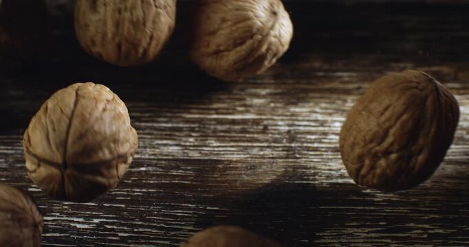 Walnuts Bouncing on Wooden Surface in Slow Motion  Close-Up of Whole Nuts in Motion Capturing Texture, Organic Shapes, and Natural Energy with Rustic Background at 100o fps.