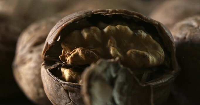 Falling Walnut Cracking Open in Slow Motion. Macro of Nut Shell Breaking to Reveal Kernel Inside, Capturing Natural Texture, Energy, and the Moment of Impact with Fine Detail at 1000 fps.