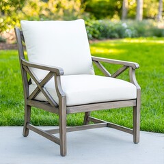 A weathered gray crossback chair with plush off-white cushions sits invitingly on a lush green lawn providing a comfortable outdoor seating option perfect for relaxation and