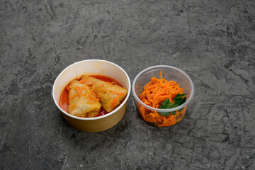 set with Ukrainian dish cabbage rolls with carrots in disposable dishes